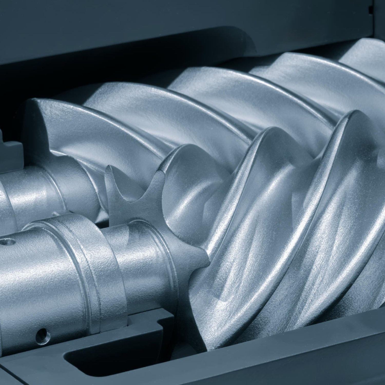 Silver gear with a pointed end and a spiral shape. The spiral shape is very sharp and the gear is very shiny.